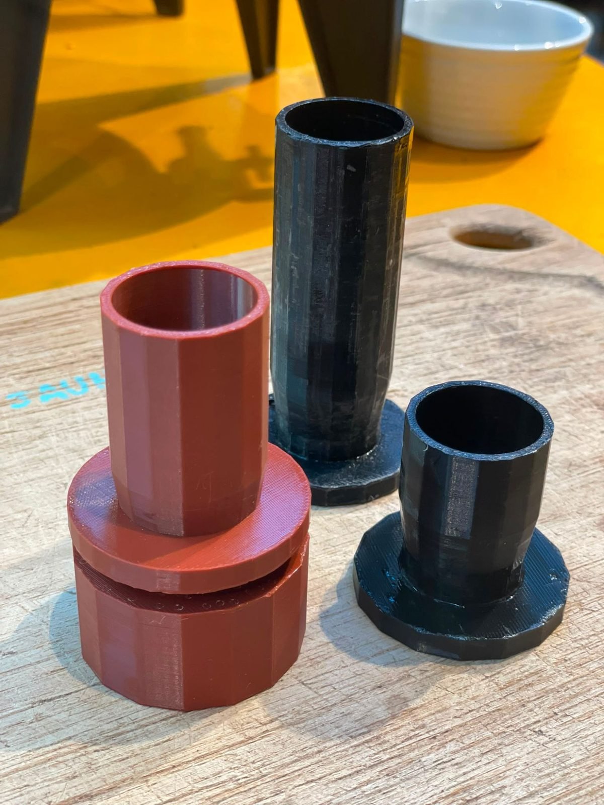 Trois adaptateurs vrac imprimés en 3D, un rouge et deux noirs