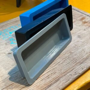 Trois bacs rectangulaires imprimés en 3D, bleu, noir et gris, emboîtés